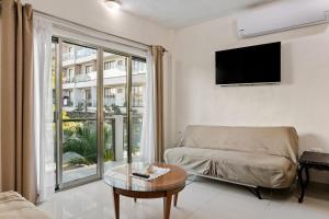a living room with a couch and a tv at Departamento de la quinta in Playa del Carmen