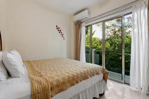 a bedroom with a bed and a large window at Departamento de la quinta in Playa del Carmen