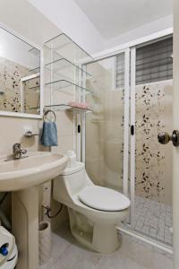 a bathroom with a toilet and a sink and a shower at Departamento de la quinta in Playa del Carmen +12 photos