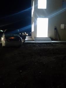 um carro estacionado em frente a um prédio à noite em The Fog mountain em Kerak