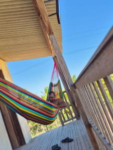 a woman is sitting in a hammock with at Pousada degamix in Barroquinha +8 photos