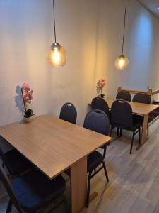 a meeting room with two tables and chairs and lights at Værelser til leje 5 in Hørve