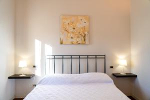 ein Schlafzimmer mit einem Bett und zwei Lampen an Tischen in der Unterkunft Casa Marilyn in Desenzano del Garda