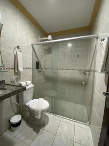 a bathroom with a toilet and a glass shower at Marbello Ariau Hotel in Fortaleza