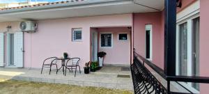 a pink house with a table and chairs on the porch at CasaCorn in Stavrákion