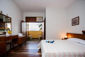 a bedroom with a bed and a desk and a sink at Praia Sol Hotel - Leme Hotel Ltda in Serra