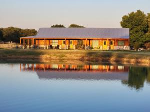 a building next to a large body of water at Private Retreat with Pond, Pool and Hot Tub in Boyd