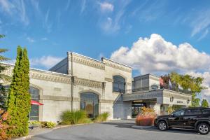 a black car parked in front of a building at Best Western Hotel Universel Drummondville in Drummondville