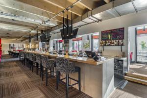 Best Western Hotel Universel Drummondville في دراموندفيل: بار في مطعم مع صف من المقاعد المرتفعة