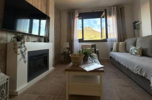 a living room with a couch and a fireplace at Apartamentos Consuegra frente a los molinos in Consuegra +131 photos
