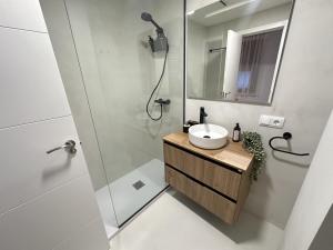 a bathroom with a sink and a shower at Apartamentos Consuegra frente a los molinos in Consuegra