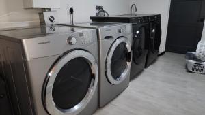 2 Waschmaschinen sowie eine Waschmaschine und ein Trockner in einem Zimmer in der Unterkunft Forest City Room Family Style Room 2 in London