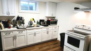 eine Küche mit weißen Schränken und einem weißen Herd mit Backofen in der Unterkunft Forest City Room Family Style Room 2 in London