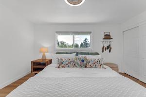 a bedroom with a white bed with pillows and a window at Evergreen Garden Wi-Fi available close to Nike Intel Hospital Downtown in Portland