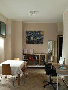 ein Wohnzimmer mit Tisch und Stühlen in der Unterkunft Ampio monolocale vicino al lungolago di Lecco in Lecco