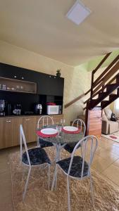 a dining room table with two chairs and a kitchen at Apto 13 - Residencial Canaã in Porto Velho