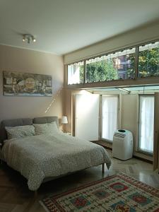 ein Schlafzimmer mit einem Bett und einem großen Fenster in der Unterkunft Ampio monolocale vicino al lungolago di Lecco in Lecco