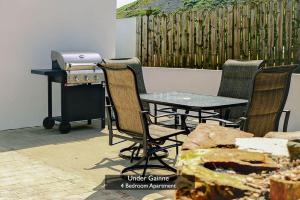 a patio table and chairs with a grill and a table and chairsuggest at Under Gáinne #1 in Downings