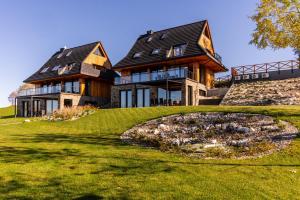 a large house on top of a grassy hill at Janiołów Wierch 43 Jacuzzi i Sauna in Groń