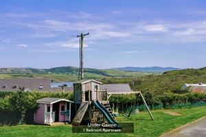 a small house with a slide in the yard at Under Gáinne #1 in Downings +20 photos