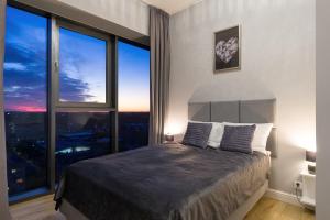 ein Schlafzimmer mit einem Bett mit einem großen Fenster in der Unterkunft HANZA TOWER HIGH FLOOR Swimming Pool & Spa in Stettin + 24 Fotos