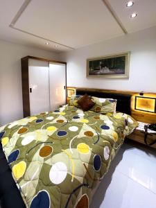 a bedroom with a large bed with a colorful comforter at Belle appartement a mahdia plage in Kenitra +7 photos