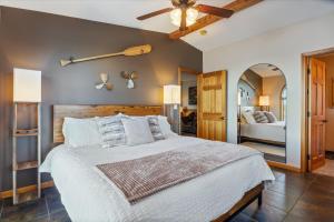 a bedroom with a large bed with a ceiling fan at Cozy Digs Lake Lodge w/ 2 Decks, Game Room, Private Dock & Boat Slip in Osage Beach