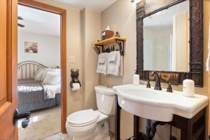 a bathroom with a sink and a toilet and a mirror at Cozy Digs Lake Lodge w/ 2 Decks, Game Room, Private Dock & Boat Slip in Osage Beach +52 photos