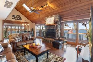 a living room with a couch and a fireplace at Cozy Digs Lake Lodge w/ 2 Decks, Game Room, Private Dock & Boat Slip in Osage Beach