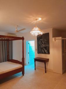 a bedroom with a bed and a chandelier at Elegant Double Big Room at Villa Paradise in Diani Beach