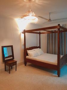 a bedroom with a canopy bed and a mirror at Elegant Double Big Room at Villa Paradise in Diani Beach