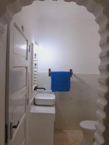 a bathroom with a toilet and a blue towel at Elegant Double Big Room at Villa Paradise in Diani Beach