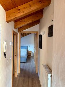 a hallway with a bed in a room with wooden ceilings at Sky Lodge Bellamonte in Bellamonte