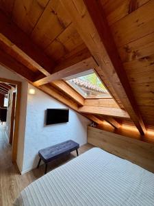 a attic room with a bed and a tv at Sky Lodge Bellamonte in Bellamonte