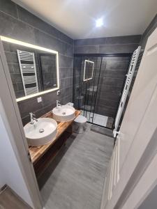 a bathroom with two sinks and a toilet at Jolie T4 rénové avec balcon-terrasse in Argeliers