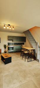 eine Küche mit einem Tisch und Stühlen sowie eine Treppe in der Unterkunft Charmante maison à Denain en couple ou solo in Denain