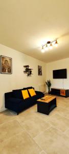 ein Wohnzimmer mit Couch und Flachbildfernseher in der Unterkunft Charmante maison à Denain en couple ou solo in Denain