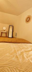 ein Zimmer mit einem Bett mit einem Spiegel und einem Tisch in der Unterkunft Charmante maison à Denain en couple ou solo in Denain