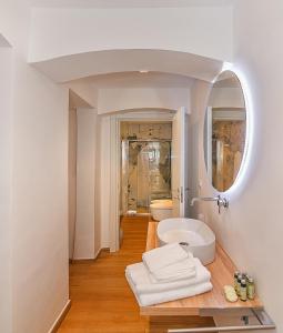 a white bathroom with a sink and a mirror at Tirreno Beachfront Apartments in Marina di Massa
