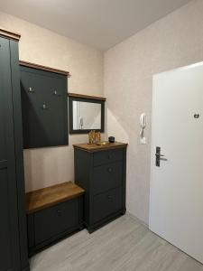 a bathroom with black cabinets and a bench and a window at Apartmán Lottner in Kysucké Nové Mesto +46 photos