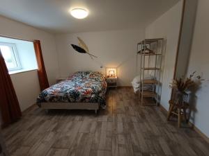 a bedroom with a bed and a wooden floor at Maison de campagne avec parking et WIFI in Sées