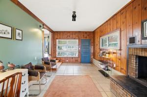 a living room with a fireplace and wooden walls at The Stoop On Spencer Drive in Van Wert