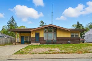a yellow house with a blue door at The Stoop On Spencer Drive in Van Wert
