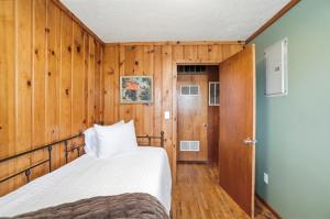 a bedroom with a bed and wooden walls and a door at The Stoop On Spencer Drive in Van Wert