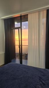 une chambre avec un lit avec vue sur l'océan dans l'établissement NBG Aparthotel, à Batoumi