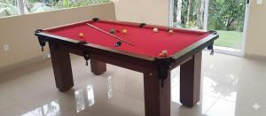 einem roten Billardtisch mit Bällen darüber in der Unterkunft Sítio Morada do Pai com Piscina - CTG Silva Neto in Canelinha