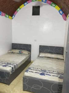 two beds in a room with an arch over them at منزل نوبي إضافة in Aswan