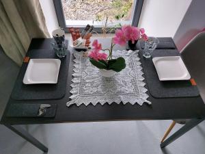 a black table with two plates and flowers on it at Ubytovanie Čadca in Čadca