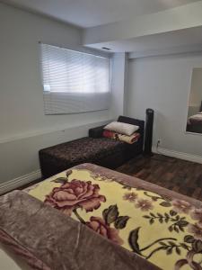 a room with a bed and a couch with a blanket at Enjoy Life in Heart of North Delta in Delta