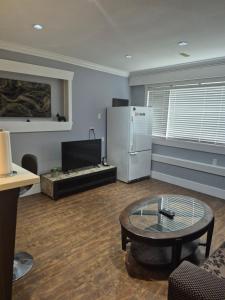 a living room with a refrigerator and a table at Enjoy Life in Heart of North Delta in Delta